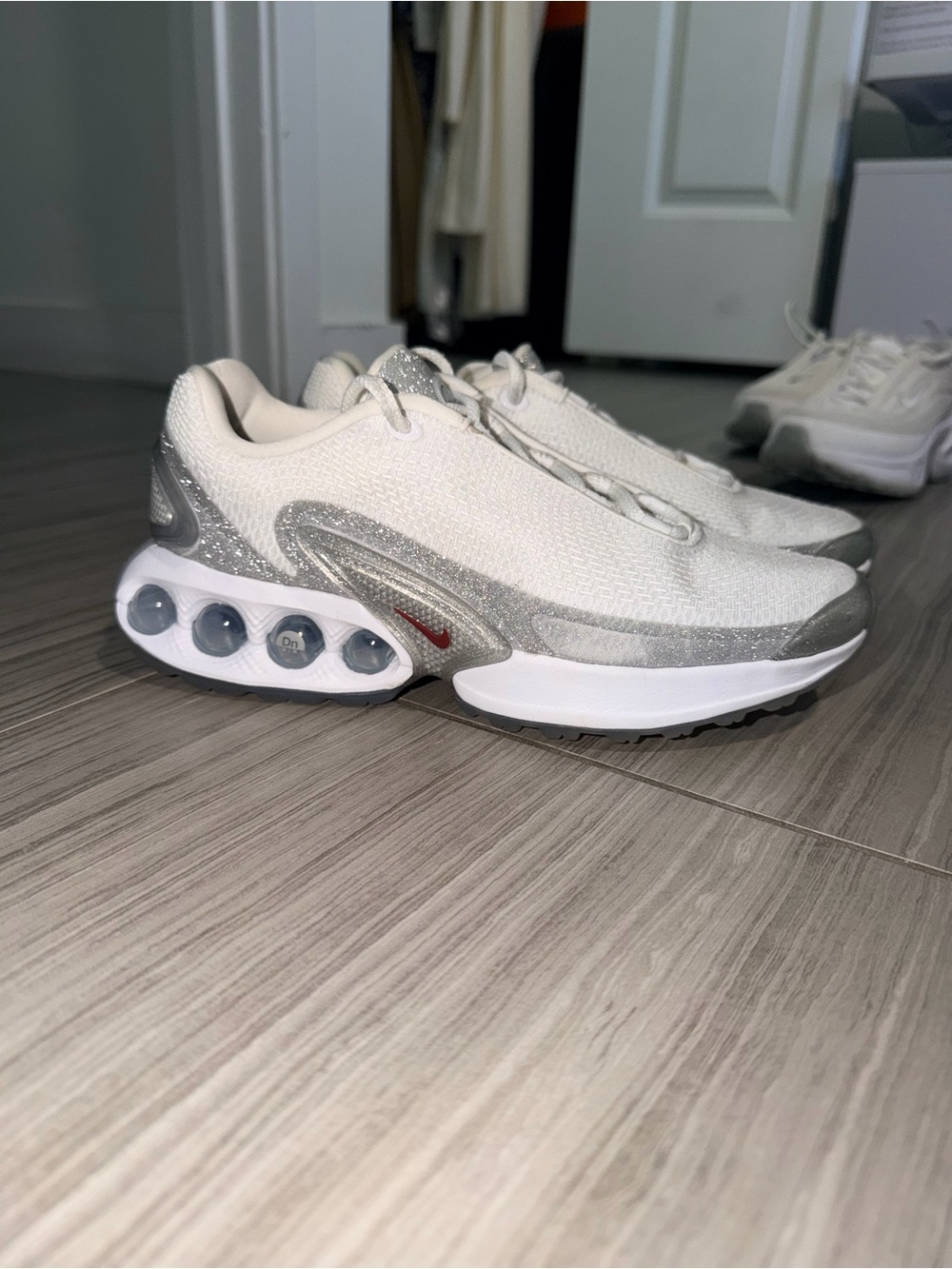 Nike Women's White and Silver Running Sneakers with Subtle Red Accent
